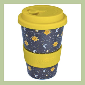 a rice husk travel cup with yellow lid and sleeve with stars suns and moon celestial design on a white background
