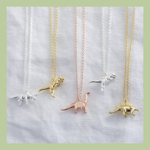 five dinosaur charm necklaces in silver gold and rose gold