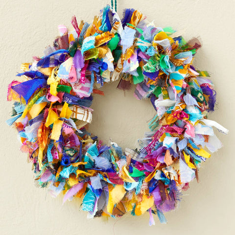 Colorful fabric wreath with a decorative hook on a beige background