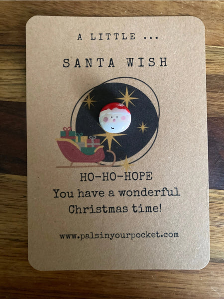 Kraft paper card with Santa Claus illustration and Christmas message on a wooden surface