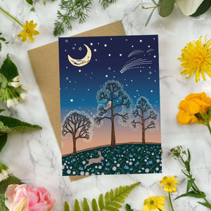 Greeting card with nature-themed design surrounded by flowers and leaves on a marble surface