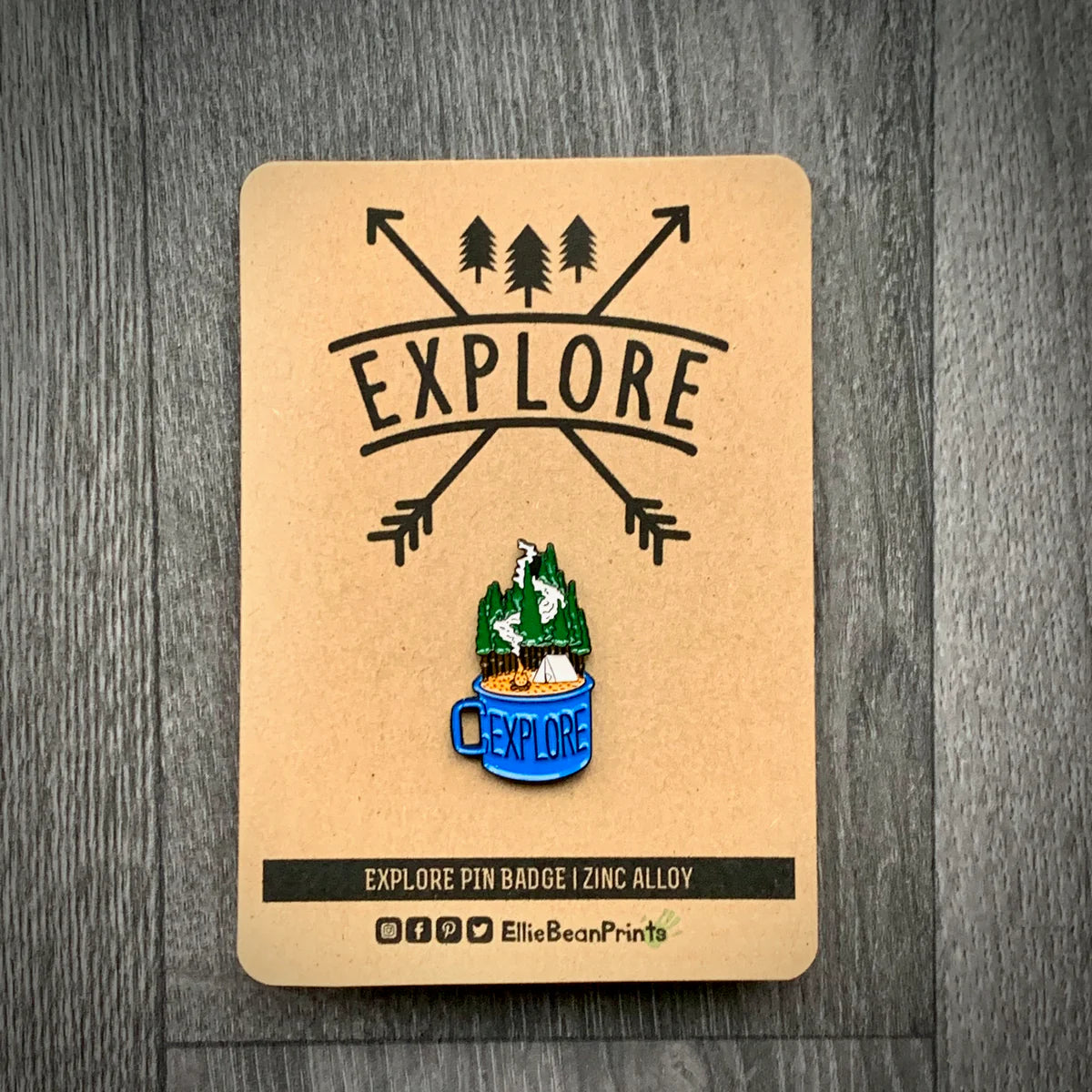 Pin badge with 'EXPLORE' design on a cardboard backing