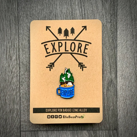 Pin badge with 'EXPLORE' design on a cardboard backing