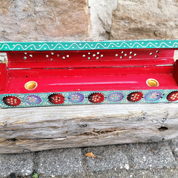 Decorative incense holder with colorful patterns on a stone surface