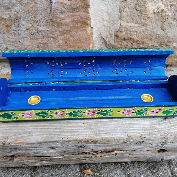 Decorative blue box with floral patterns on a stone surface