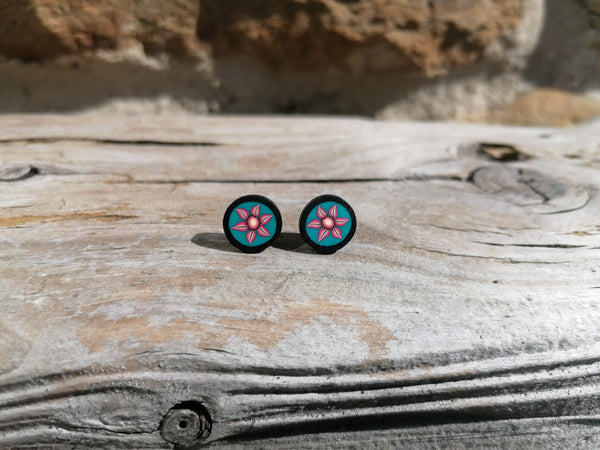 Pair of flower-patterned earrings on a wooden surface