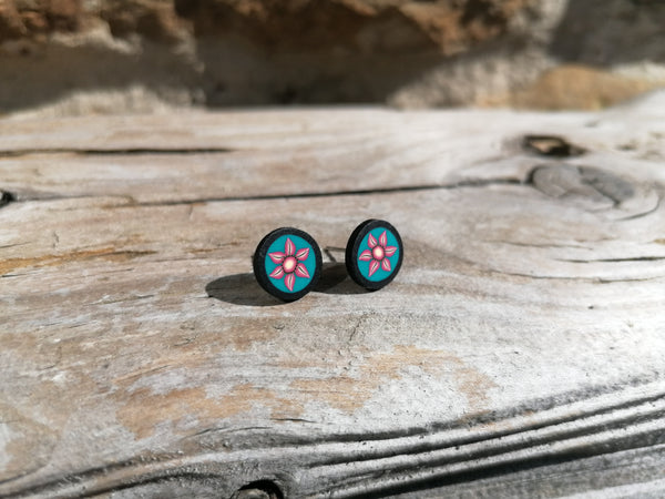 Floral stud earrings on a wooden surface