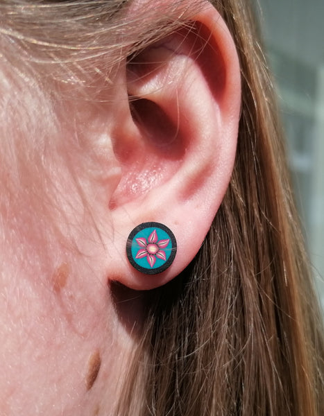 Close-up of an ear with a floral stud earring.