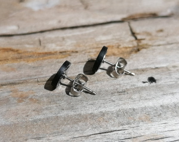 Silver stud earrings on a wooden surface