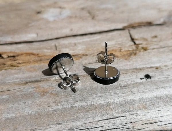 Silver stud earrings on a wooden surface