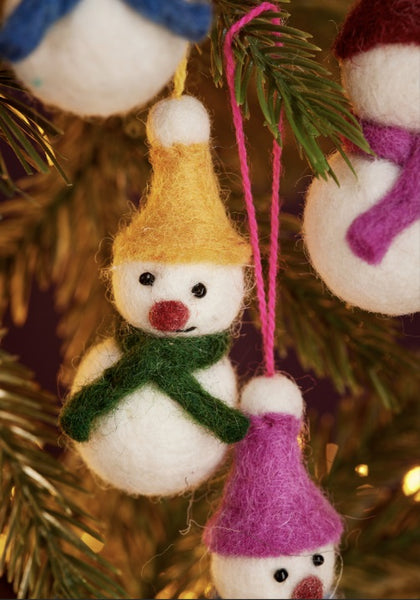Felt snowman ornaments with colorful hats and scarves hanging on a Christmas tree.