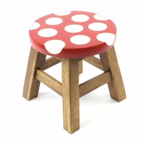 Wooden stool with a red polka dot top on a white background