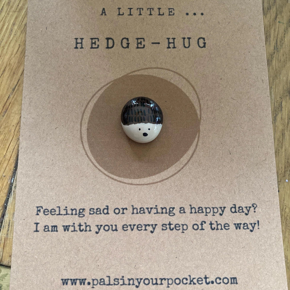 Small round hedgehog-shaped object on a brown card with text