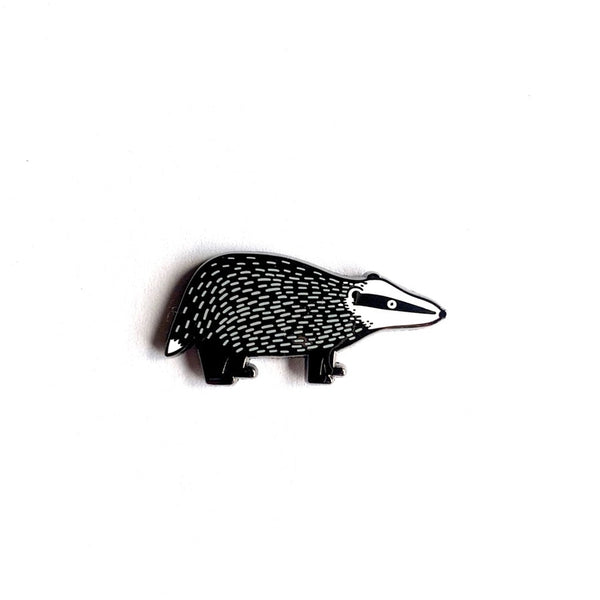 Black and white enamel badger pin on a white background
