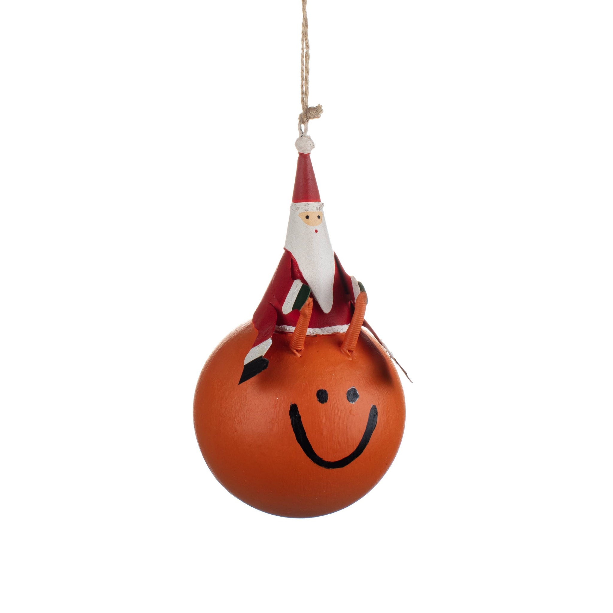 Orange ball with a smiley face and Santa hat hanging on a white background