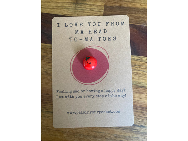 Card with a red button and text on a wooden surface