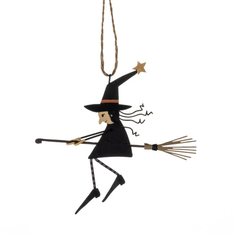 Decorative witch figure on a broomstick hanging from a string against a white background