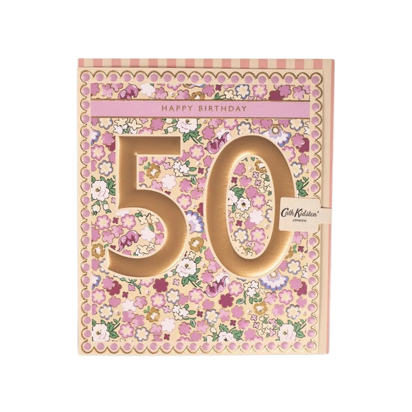 A 50th birthday card by Cath Kidston, featuring a floral pattern in shades of pink, purple, and green on a beige background, with large gold-toned '50' numerals and a small brand tag on the right side.