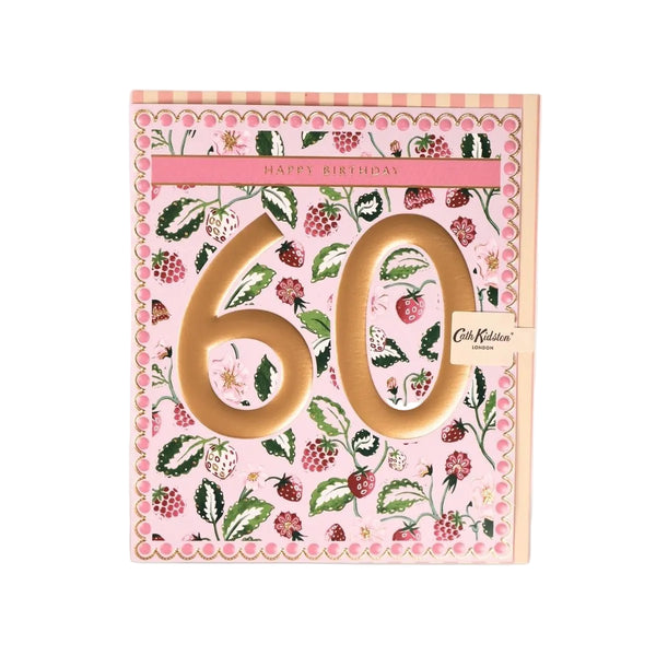 A pink 60th birthday card featuring a strawberry and raspberry floral pattern, with large gold '60' numerals and a small 'Cath Kidston' tag on the right side, shown against a white background.