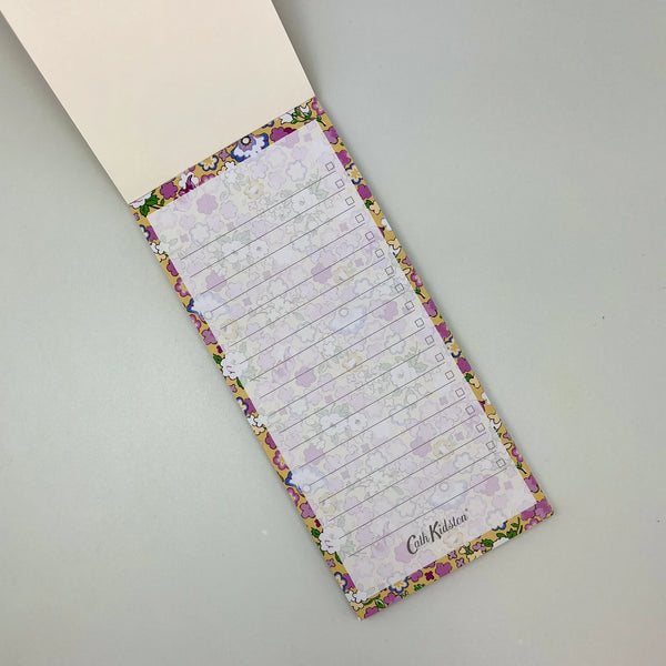 Floral-patterned notepad with checklists on a gray surface