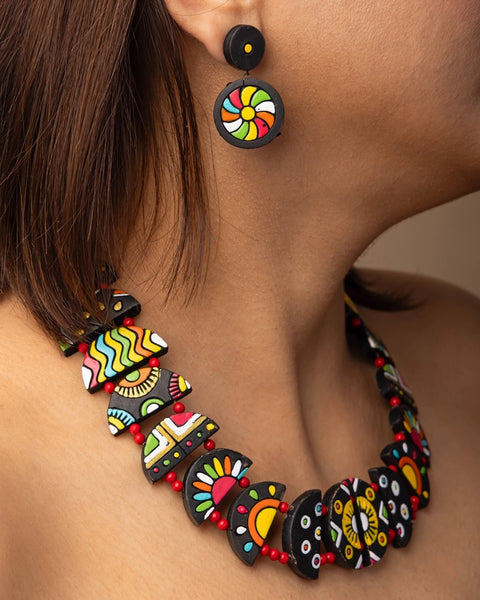Colorful necklace and earrings on a person against a neutral background