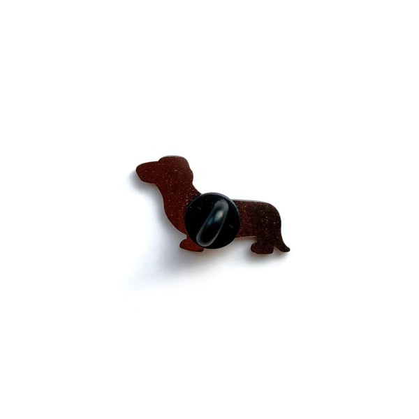 Brown dog-shaped object with a black button on a white background