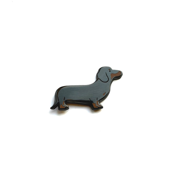 Dog-shaped brooch on a white background