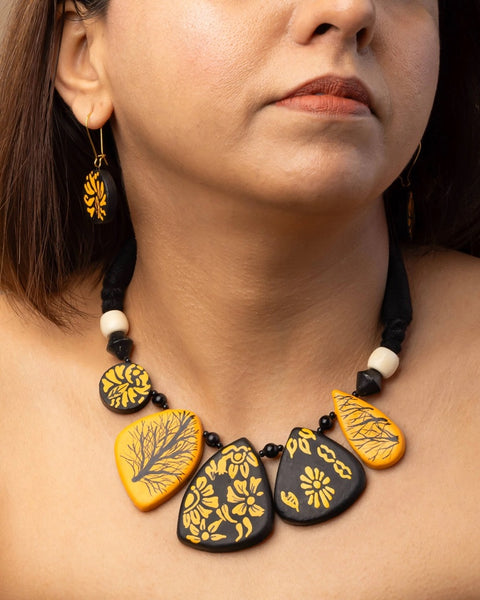 Woman wearing a necklace with yellow and black pendant details