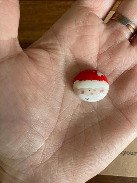 Small round object with a face design held in a hand