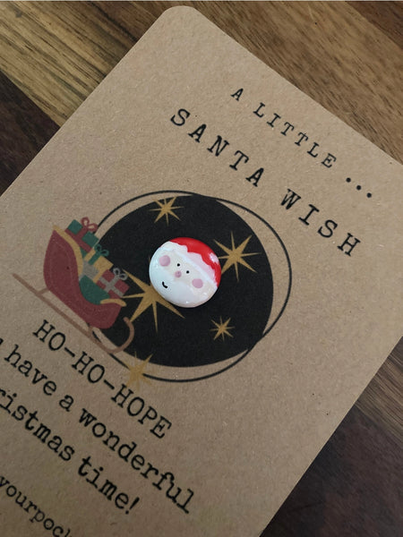 Card with Santa Claus illustration and text on a wooden surface