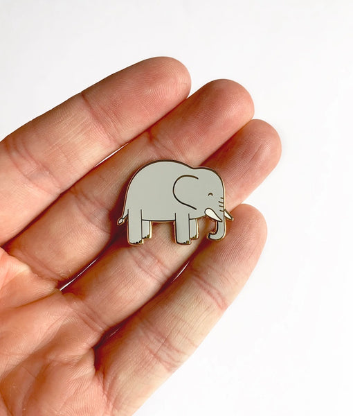 Small elephant-shaped object held in a hand against a white background