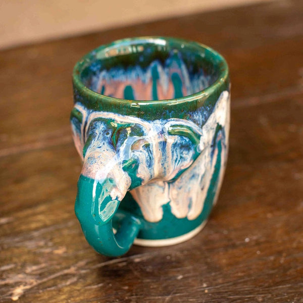 Ceramic mug with artistic design on a wooden surface