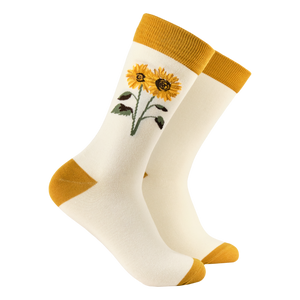 White socks with yellow sunflower design and matching cuffs and toes on a white background