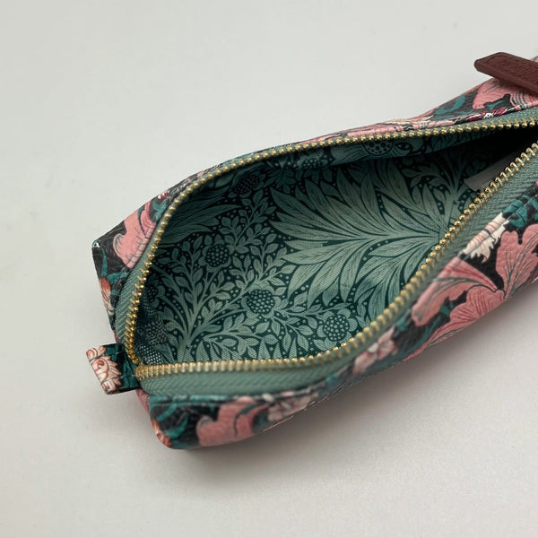 Floral patterned pouch with a gold zipper on a light gray background