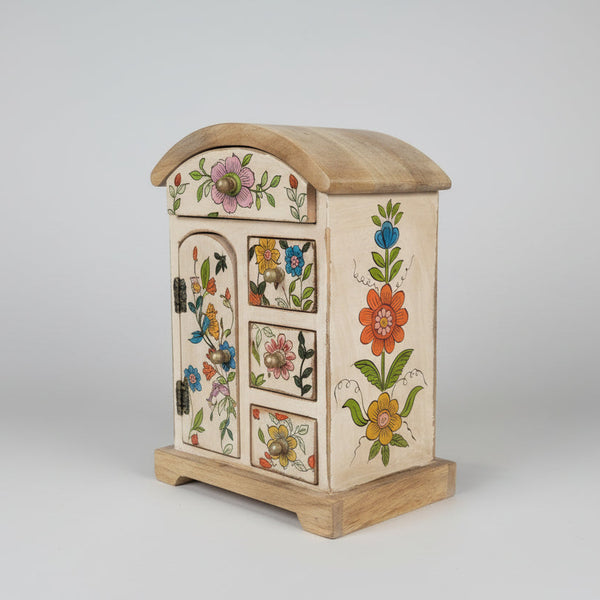 Wooden jewelry box with floral designs on a table