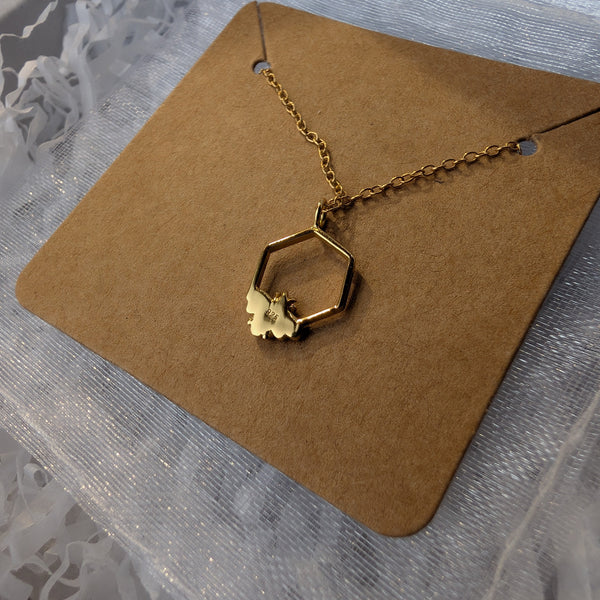 Gold necklace on a brown card with a textured gray background