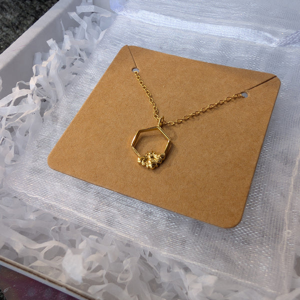 Gold necklace on a brown card with white shredded paper