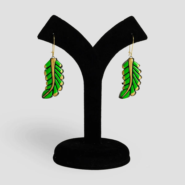Green leaf-shaped earrings on a black Y-shaped stand against a light gray background