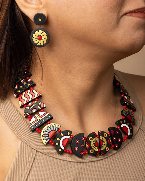 Close-up of a person wearing a colorful beaded necklace and earrings.