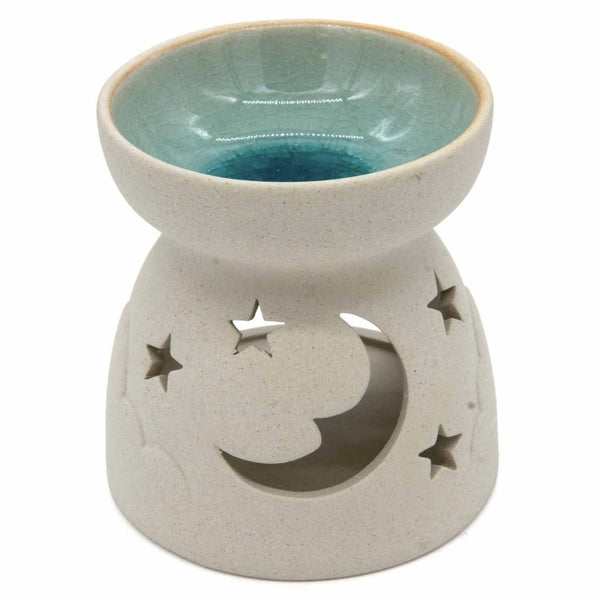 A ceramic oil burner lamp with a speckled light beige body, featuring a crescent moon and star cutout design on the front. The top bowl has a glossy light blue-green glazed interior, set against a plain white background.
