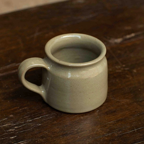 Small ceramic mug on a wooden surface