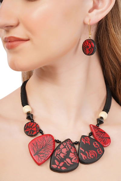 Necklace with red and black leaf-shaped pendants on a model against a white background