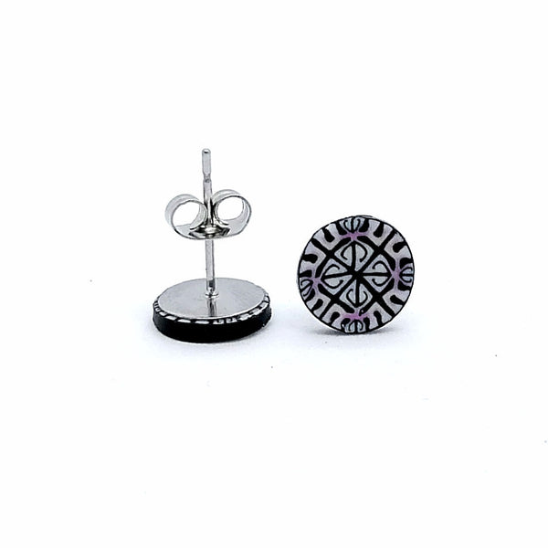 Black and white patterned earring on a stand against a white background