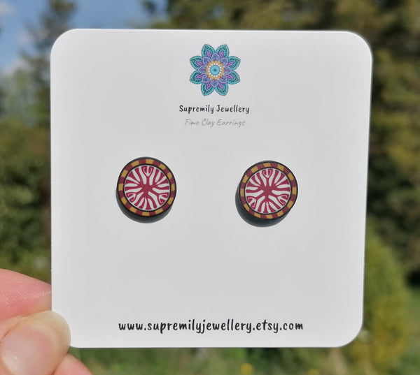 Pair of round earrings on a Supremily Jewellery card with a blurred natural background