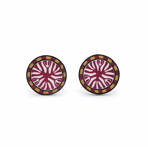 Pair of round earrings with a red and gold design on a white background
