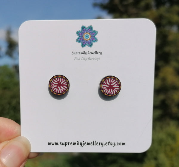 Round earrings on a Supremily Jewellery card with a blurred natural background