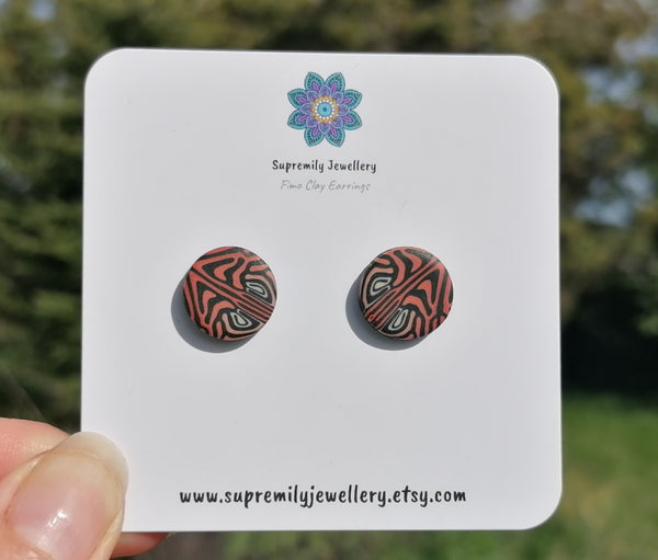 Pair of patterned earrings on a Supremily Jewellery card with a blurred natural background