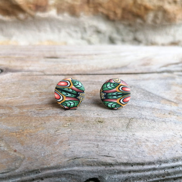 Pair of colorful round earrings on a wooden surface