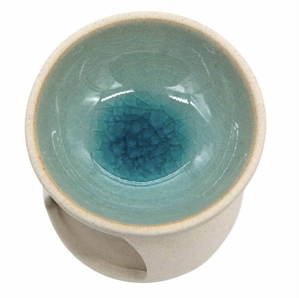 A ceramic tea cup with a light beige exterior and a glazed interior featuring a gradient from pale aqua to deep teal with a crackle glaze pattern.