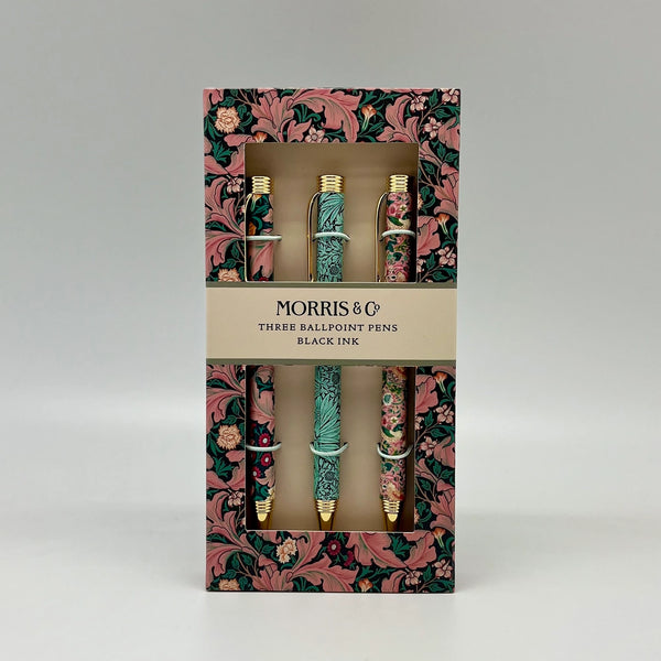 Packaged set of three ballpoint pens with floral design on a gray background